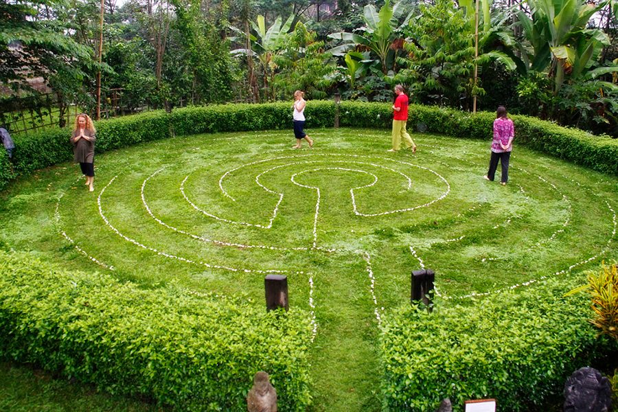 Guests walk along a garden maze at Bali Silent Retreat. 